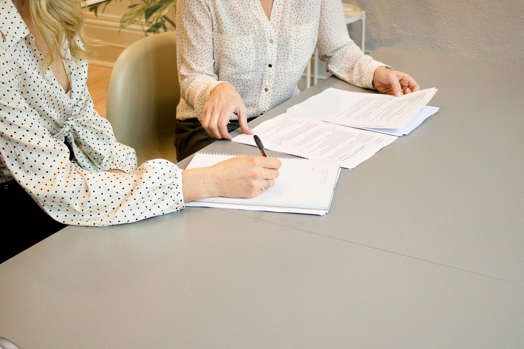 Two people working through enrollment paperwork together at a table.